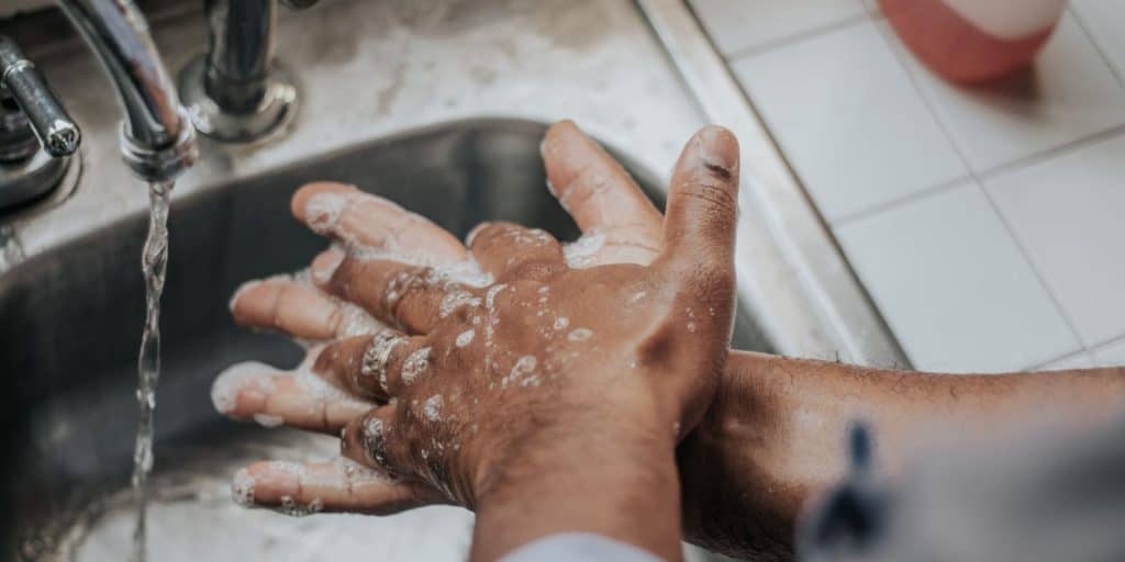 person washing hands in a sink